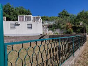 a fence in front of a white building at Filipova vikendica in Peroči