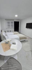 a white room with two beds and a table in it at Airport Apartment Masa in Mitrovići