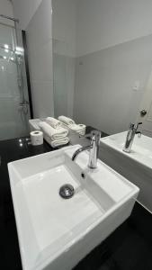 a white bathroom with a sink and a mirror at Mercedes Rambla Hotel in Mercedes +26 photos