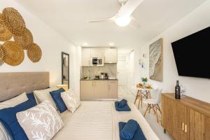 a living room with a couch and a flat screen tv at Ocean Aura Tenerife in Costa de Adeje