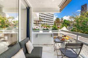 a balcony with a couch and a table and chairs at Ocean Aura Tenerife in Costa de Adeje