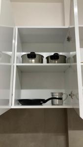 two pots and pans on shelves in a kitchen at Ap Doce Lar in Espargos +5 photos