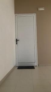 a white door in a white room with a tile floor at Ap Doce Lar in Espargos