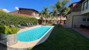 a swimming pool in a yard next to a house at Mercedes Rambla Hotel in Mercedes