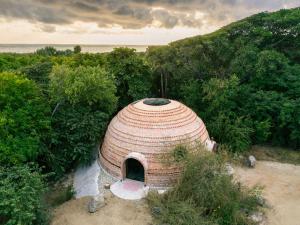 a large building with a straw roof in a forest at Casa Sal by Tasman in Puerto Escondido