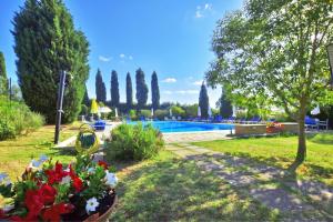 a garden with a swimming pool and some flowers at Casa Guna - Happy Rentals in Asciano