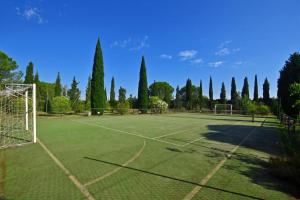 a tennis court with a net and trees at Casa Guna - Happy Rentals in Asciano +22 photos