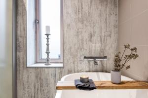 ein Badezimmer mit Badewanne und Spiegel in der Unterkunft Circuitus in Växjö + 50 Fotos