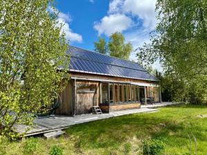 ein Holzgebäude mit Terrasse auf einem Feld in der Unterkunft Circuitus in Växjö