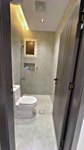 a bathroom with a white toilet and a shower at شقق الياسمين الفندقية in Medina