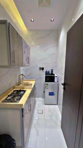 a white kitchen with a stove and a sink at شقق الياسمين الفندقية in Medina +17 photos