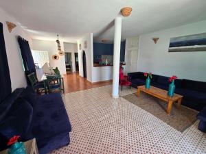 a living room with blue couches and a table at lagoon apartement 1 in Moulay Bousselham