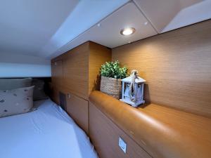 a bedroom with a bed and a plant on a shelf at ΡΕΝΤ ΜΕ ΟΥΤ Σιμπα in Kavála