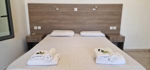 a bedroom with a bed with towels on it at Paralia Hotel & Taverna in Agia Roumeli
