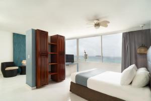 a bedroom with a bed and a large window at Calypso Beach Hotel in San Andrés