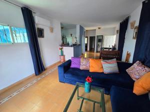 a living room with a blue couch with colorful pillows at lagoon apartment 4 in Moulay Bousselham