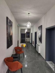a hallway with orange chairs and a living room at Golden Guesthouse in Resen