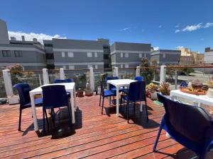 a deck with tables and chairs on a balcony at Hostería Altea in Monte Hermoso