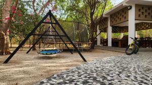 a swing set in front of a building at Suñu Tool Private Farm Guesthouse in Sindia