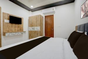 a bedroom with a white bed and a tv at Hotel O Viraj Inn in Gwalior +21 photos