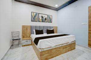 a bedroom with a large bed and two paintings on the wall at Hotel O Viraj Inn in Gwalior