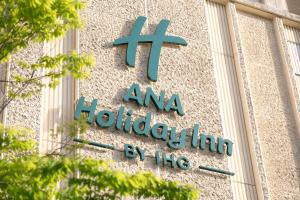 a sign on the side of a building at ANA Holiday Inn Kobe Sanda by IHG in Sanda