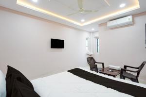 a bedroom with a bed and a tv on the wall at HOTEL O KMG GRAND in Bībīnagar