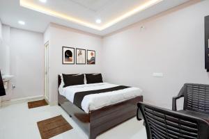 a bedroom with a bed and a chair in it at HOTEL O KMG GRAND in Bībīnagar +25 photos