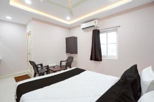 a bedroom with a bed and a table and chairs at HOTEL O KMG GRAND in Bībīnagar
