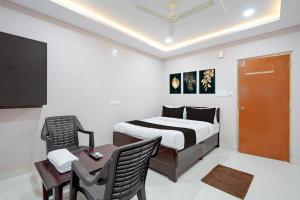 a bedroom with a bed and a table and a desk at HOTEL O KMG GRAND in Bībīnagar