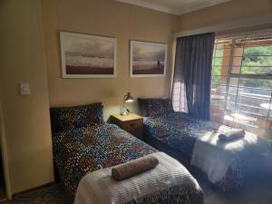 a bedroom with two beds and a window at Pink Pepper Yard in Uniondale