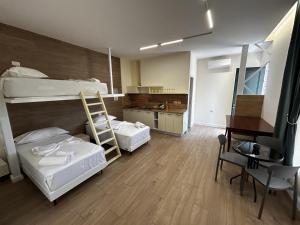 a room with two bunk beds and a desk at The Bearded Dad Hostel in Tirana
