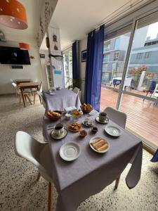 a table with plates of food on it in a room at Hostería Altea in Monte Hermoso