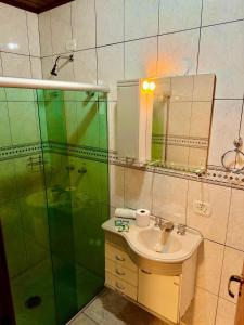 a bathroom with a sink and a glass shower at Pousada D' Paula in Campos do Jordão +48 photos