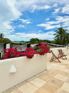 a balcony with pink flowers on a white wall at Casa boa vida in Jericoacoara