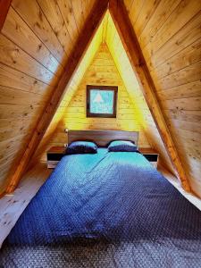 a bed in a wooden cabin with a roof at Vila Mila in Vlaška +27 photos