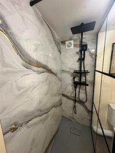 a bathroom with a white marble wall at A l'ombre de la Tour in Lourdes +38 photos
