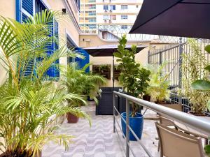a balcony with a bunch of plants and an umbrella at Injoy Suítes & Aparts in Rio de Janeiro