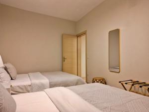 a room with two beds and a mirror at Asul Seaside Retreat in Stavros