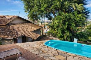 a swimming pool on top of a wooden deck at Casa da Praia Costazul in Rio das Ostras