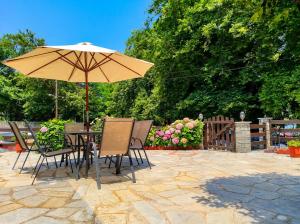 a table and chairs with an umbrella on a patio at Elias Studio & Apartment near Papa Nero Beach Pelion in Agios Ioannis Pelio