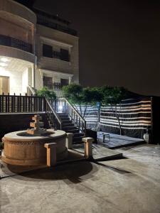 a fountain in front of a building with a staircase at Rabab3a Hotel in Ajloun