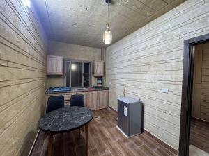 a small room with a table and a kitchen at Rabab3a Hotel in Ajloun