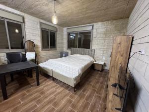 a bedroom with a bed and a desk in it at Rabab3a Hotel in Ajloun
