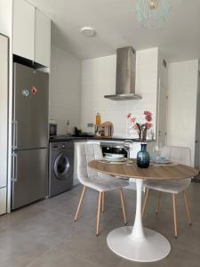 a kitchen with a table and chairs and a refrigerator at Modern Studio Lamar Resort in Pilar de la Horadada