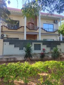 a house with balconies and plants in front of it at Super Lodge by HFI in Islamabad