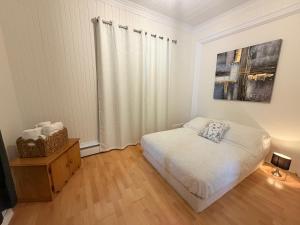 a bedroom with a bed and a dresser and a window at La Suite du Havre in Saint-Charles-des-Grondines