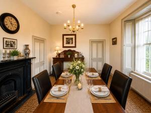 a dining room with a table with chairs and a clock at Nore View House in Kilkenny