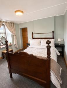 a bedroom with a large wooden bed with white sheets at Nore View House in Kilkenny