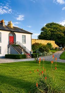 a white house with a red door and a yard at Nore View House in Kilkenny
